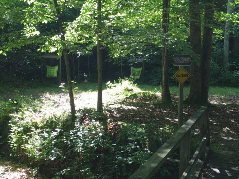 Wooded archery range with a trail sign at a public recreation area