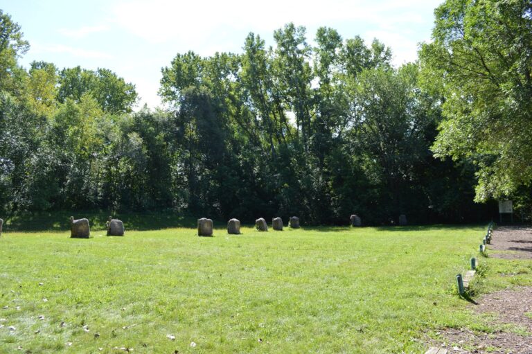 Outdoor archery range with target bales along a mowed field edge
