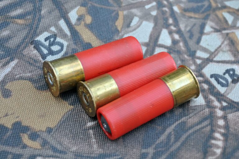 Three red shotgun shells on a camouflage background